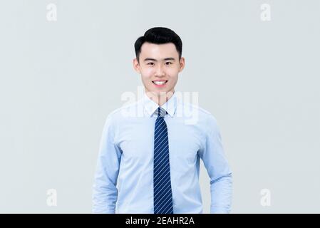 Junge gut aussehende asiatische professionelle Mann in Business-Shirt und Krawatte Mit frischen sauber rasiert Aussehen nach Kamera und lächeln isoliert Auf hellgrauem BA Stockfoto