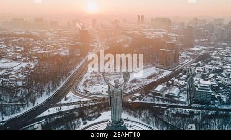 Panorama-Luftaufnahme der Winterstadt Kiew im Schnee bedeckt. Das Mutterland Monument Stockfoto