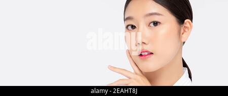 Nahaufnahme der hübschen asiatischen Frau mit Händen berühren Gesicht Isoliert auf weißem Banner-Hintergrund mit Platz zum Kopieren für Schönheit Und Hautpflegekonzepte Stockfoto