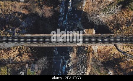 Wunderschöne neblige Morgenansicht auf eine Brücke über die Eisenbahn Verbindung über den Fluss im Berg Stockfoto