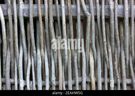 Ein rustikaler Weidenzaun in Nahaufnahme. Zaun aus braunen Holzstäben in einem ukrainischen Dorf. Holzhintergründe und Texturen. Hochwertige Fotos Stockfoto