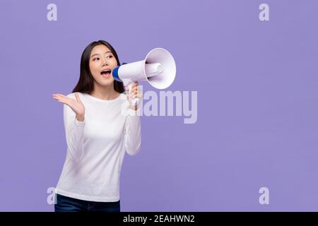 Schöne asiatische Frau kündigt auf Magaphon isoliert auf lila Hintergrund Mit Kopierbereich Stockfoto