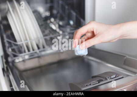 Frau putting Tablet in der Spülmaschine Reinigungsmittel, Stockfoto
