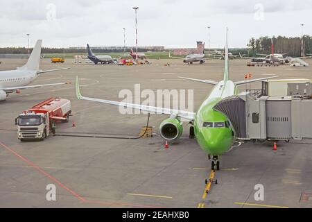 Passagierflugzeug mit Einstiegsstufen, das vor dem Flug auf das Einsteigen von Passagieren und Gepäck wartet Stockfoto