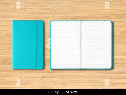 Aquablue geschlossene und offene linierte Notizbücher auf Holzhintergrund Stockfoto