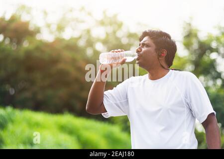 Sport Läufer schwarz Mann tragen Sportler Kopfhörer er Trinkwasser Aus einer Flasche Stockfoto