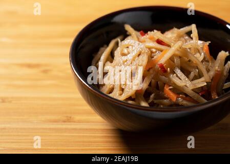 Kinpira Klette auf einem hölzernen Hintergrund Stockfoto