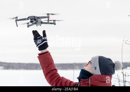 Russland Wyborg. 02.02.2021 EIN junger Mann startet im Winter einen Quadcopter. Hochwertige Fotos Stockfoto