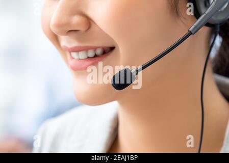 Nahaufnahme einer lächelnden Frau im Kundenservice, die ein Mikrofon trägt Headset im Callcenter Stockfoto