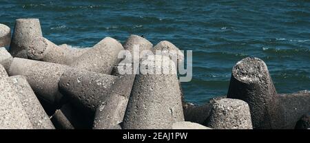 Große Steine liegen am Strand vor den Wellen. Stockfoto