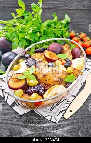 Hähnchen mit Früchten und Tomaten in Glaspfanne auf dunkel Platine Stockfoto