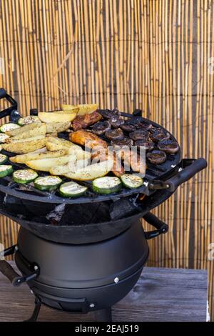 Mariniertes Huhn mit Kartoffeln auf einem Gartengrill Stockfoto