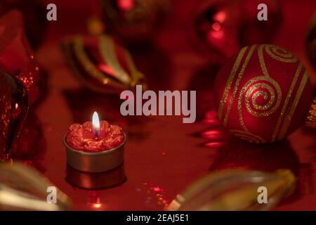 Weihnachtsstill mit roten Kugeln und Kerze Stockfoto