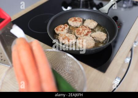 In der Küche werden Koteletts in einer Pfanne gebraten Stockfoto