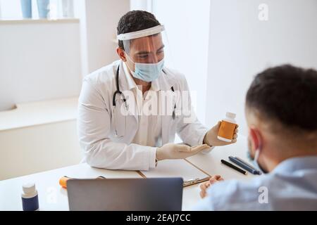 Professioneller Arzt, der das Medikament für den Patienten im Zimmer vorführt Des medizinischen Zentrums Stockfoto