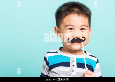 Lustige glücklich Hipster Kind hält schwarzen Schnurrbart Stockfoto