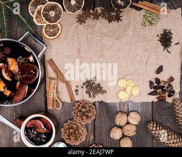 Zutaten für die Herstellung von Glühwein auf einem Holztisch und Ein Stück braunes Papier Stockfoto