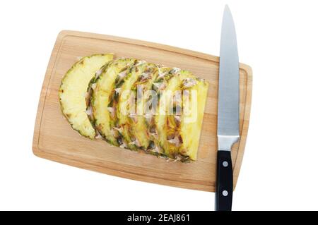 Frische Ananasscheiben auf braunem Schneidebrett. Stockfoto