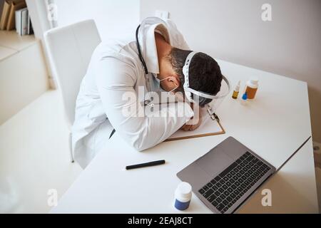 Hart arbeitenmüder Therapeut, der sich nach einem langen Tag mit Krankheit ausruhte Patienten Stockfoto