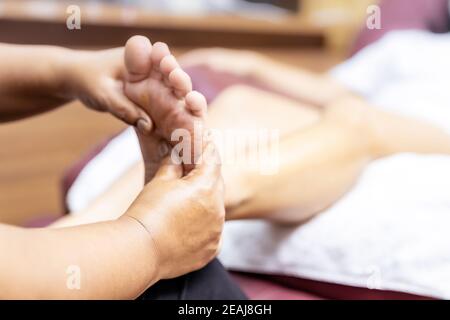 Neue normale asiatische Frau mit Gesichtsmaske tun Massage zu Hause close up. Stockfoto