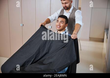 Professionelle Friseur arbeitet mit angenehmen Client im Friseursalon Stockfoto