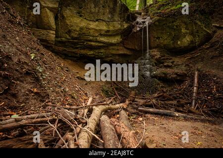 Wasserfall fällt über einen Sandsteinfelsen in einem Wald Stockfoto