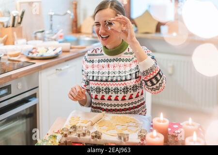 Frau in der Weihnachtsküche posiert mit Ausstechform Stockfoto