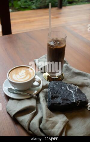 Heißer Kaffee und Eiskaffee auf hölzernen Tisch Stockfoto