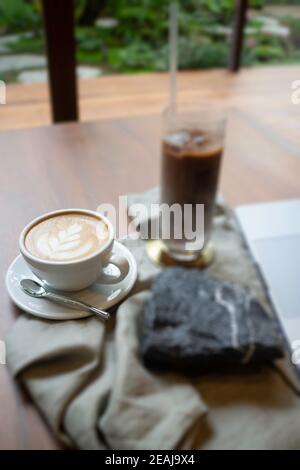 Heißer Kaffee und Eiskaffee auf hölzernen Tisch Stockfoto