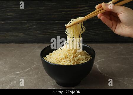 Weibliche Hand halten Essstäbchen mit Nudeln Stockfoto