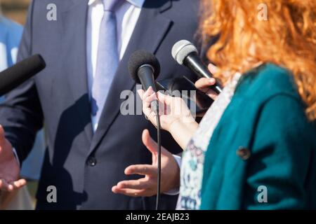 Reporter führen ein Medieninterview mit Geschäftspolitikerin oder Politiker durch Stockfoto