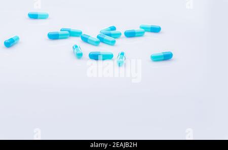 Selektiver Fokus auf blaue Kapsel Pille auf weißem Hintergrund. Pharmaindustrie. Apothekenprodukte. Gesundheitswesen und Medizin. Blaue Kapsel Pillen mit schönen Mustern. Pharmazeutische Fertigung. Stockfoto