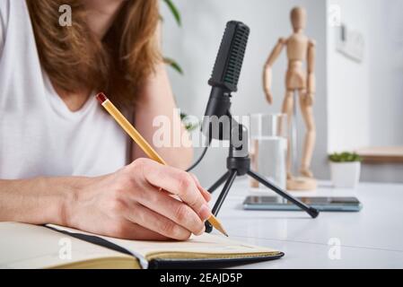 Frau, die online Podcast zu Hause. Mikrofon auf dem Tisch, Heimstudio Arbeitsplatz Stockfoto