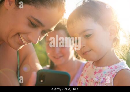 Mädchen, die auf ein Telefon schauen Stockfoto