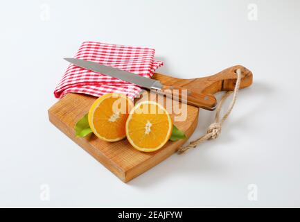 Zwei frische orange Hälften auf Schneidebrett Stockfoto