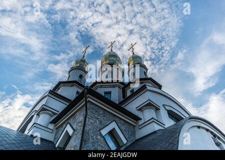 Drei Türme der orthodoxen christlichen Kirche St. Eugen mit Kuppeln und Kreuzen im Dorf. Buky, Ukraine Stockfoto
