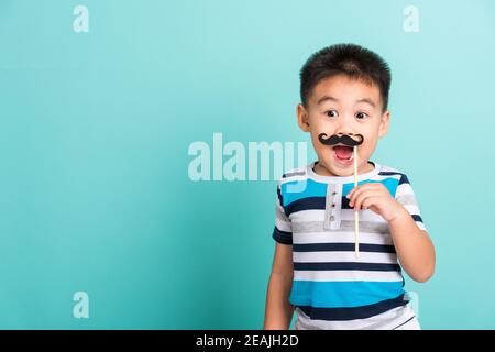 Lustige glücklich Hipster Kind hält schwarzen Schnurrbart Stockfoto