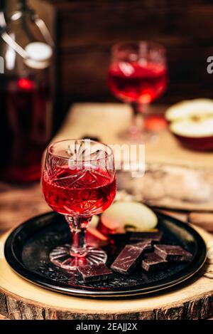 Glas hausgemachter Johannisbeere Naliwka mit Apfelscheiben und Schokolade Stockfoto