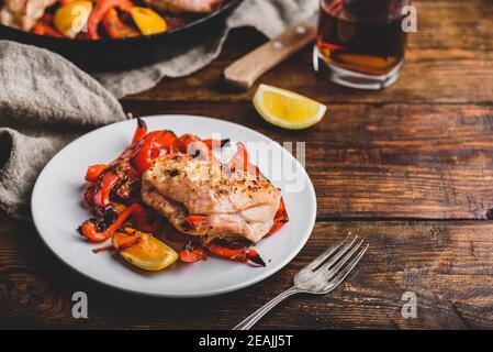 Gebackene Hähnchenschenkel mit roten Paprika und Zitrone Stockfoto