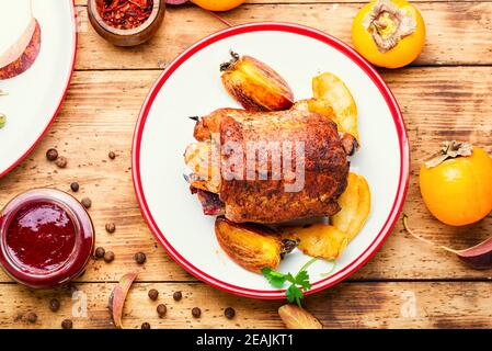 Hackbraten mit Kaki auf dem Teller Stockfoto