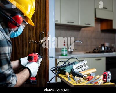 Zimmermann bei der Arbeit schützt das Gesicht mit der OP-Maske. Covid-19 Prävention. Stockfoto