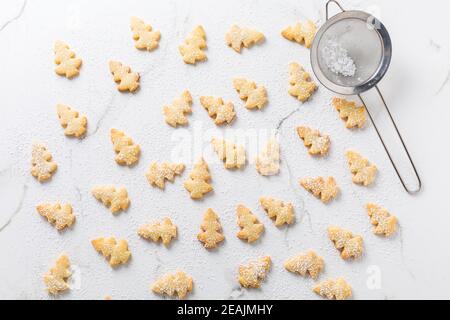 Hausgemachte Weihnachtsplätzchen in Christbaumform auf Marmorhintergrund Stockfoto