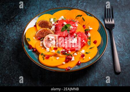 Persimmon Carpaccio Salat mit Granatapfel, Feta-Käse, rosa Grapefruit und Feigen Stockfoto