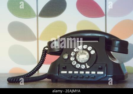 Alte Retro-und Vintage-Handy gegen bunte Tapete Stockfoto