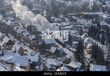 Radebeul, Deutschland. Februar 2021, 10th. Die Lößnitzgrundbahn verläuft durch Radebeul in der verschneiten Winterlandschaft. Die Schmalspurbahn, im Volksmund "Lößnitzdackel" oder "Grundwurm" genannt, hat eine Spurweite von 750 Millimetern und verläuft von Radebeul nach Radeburg. Die Züge sind derzeit spärlich befahren, ebenso wie die der anderen Bimmelbahnen in Sachsen. Aufgrund der Einschränkungen von Corona überschreiten die Züge, die hauptsächlich von Touristen genutzt werden, derzeit nicht die Kapazität von 25 Prozent. Quelle: Robert Michael/dpa-Zentralbild/dpa/Alamy Live News Stockfoto