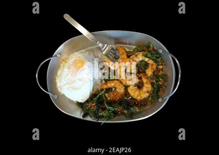 Garnelen oder Garnelen mit Basilikumblättern, Spiegeleier über Reis anbraten. Thailändisches Essen Stockfoto