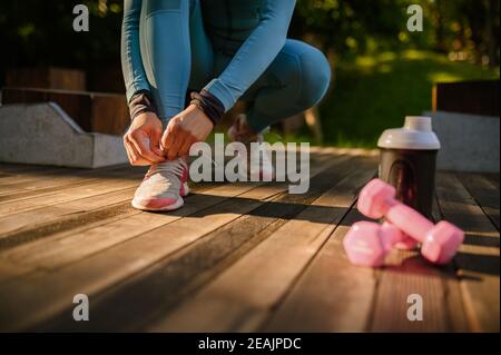 Training im Park, lächelnde Frau in Kopfhörern Stockfoto