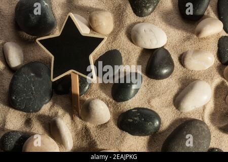 Nahaufnahme von Steinen und Sternen, die aus dem Sand ragen Im Sonnenlicht Stockfoto