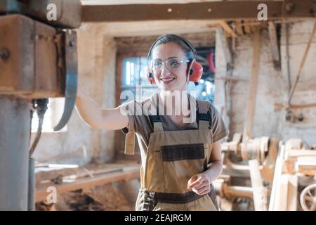 Frau Zimmermann in der traditionellen Zimmerei Einstellung der Maschine Hobel Stockfoto