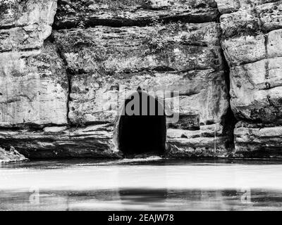 Der alte Felskanal des Flusses Ploucnice in der Sandsteinmauer bei Straz pod Ralskem in Tschechien. Schwarzweiß-Bild. Stockfoto